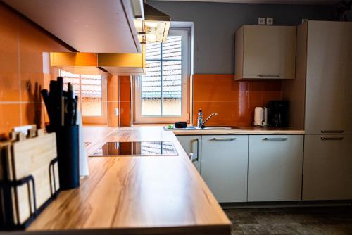 a kitchen with white cabinets and a wooden counter top at Landkulturhof Glücksbringer in Rudolstadt