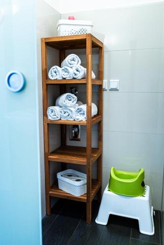 a shelf with towels and a green stool in a room at Landkulturhof Glücksbringer in Rudolstadt