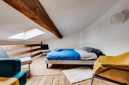 une chambre avec un lit, un canapé et une chaise dans l'établissement L'Authentique des Carmes, à Toulouse