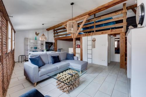 un salon avec un canapé et une table dans l'établissement L'Authentique des Carmes, à Toulouse