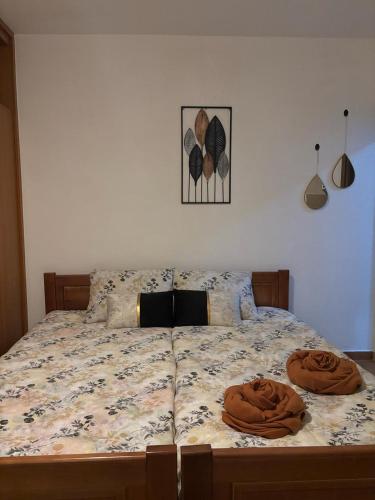 Una cama con dos almohadas marrones encima. en Nikolaj, en Podgorica