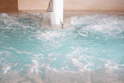 a pool of water with a fountain in it at Hotel Caesius Thermae & Spa Resort in Bardolino
