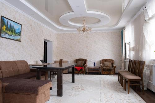 a living room with a couch and a table and chairs at Гостевой Дом Маман in Maman