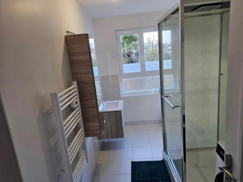 a bathroom with a glass shower and a sink at L'étage de l'Aristide proche gare parking facile in Montauban