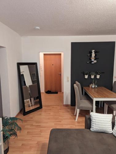 a living room with a dining room table and a mirror at Zentrumsnahe Wohnung mit Sonnenterrasse in Leipzig