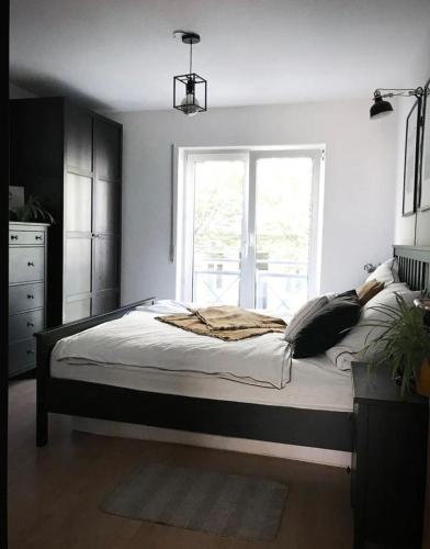 a bedroom with a large bed with a window at Zentrumsnahe Wohnung mit Sonnenterrasse in Leipzig