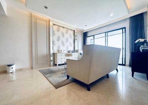 a living room with a chair and a dresser at Lavish The Peak 2BR Apartment in Tunjungan Plaza 5 Surabaya City Centre by Le Ciel Hospitality in Surabaya