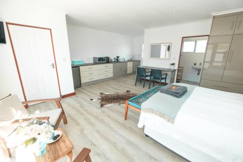 a bedroom with a large bed and a kitchen at Hermanus Reefs in Hermanus