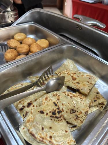 a metal tray of food with tortillas and donuts at Nejobugg Hostel in Nkoanrua
