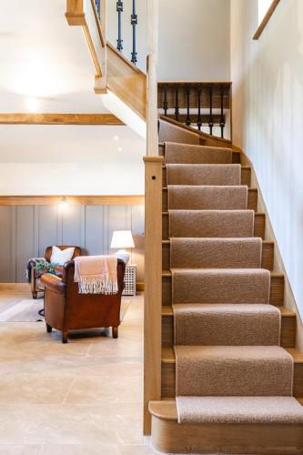 a staircase in a house with a living room at Luxury barn Retreat - sleeps 2-4, quiet location with parking in Wymondham