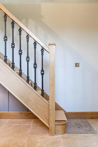 a staircase with wooden railings in a house at Luxury barn Retreat - sleeps 2-4, quiet location with parking in Wymondham