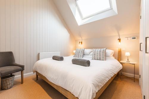 a bedroom with a large white bed with a skylight at Luxury barn Retreat - sleeps 2-4, quiet location with parking in Wymondham