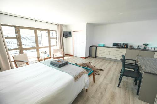 a bedroom with a large bed and a table and chairs at Hermanus Reefs in Hermanus