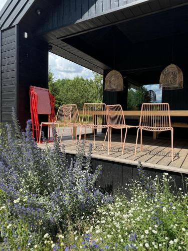 a group of chairs sitting on a wooden deck at Siedlisko Ublik in Wyszowate