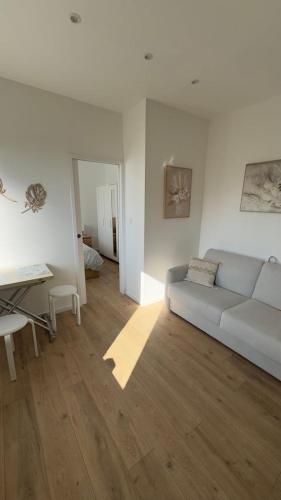 un salon blanc avec un canapé et une table dans l'établissement Bright and Modern Apartment in Dijon, à Dijon