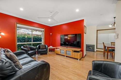 a living room with a couch and a flat screen tv at Apartments on Tolmie in Mount Gambier