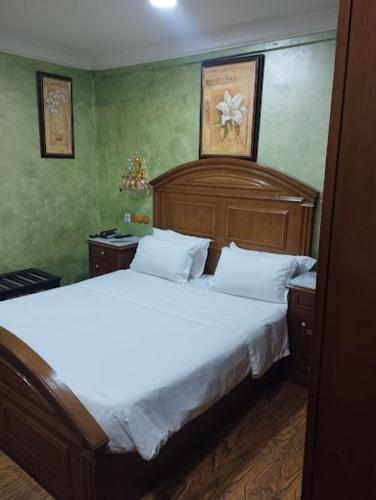 a bedroom with a large bed with white sheets at Hotel Ville Des Roses in Dilida