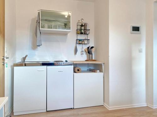 a kitchen with white cabinets and a sink at Apartment EasyLife Zentral-Ruhig in Salzweg