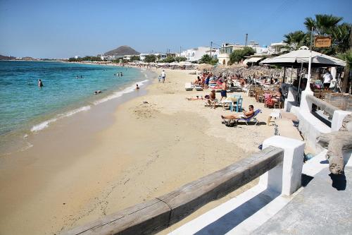 a group of people sitting on a beach at Apartments Enosis, Kalypso in Agia Anna Naxos