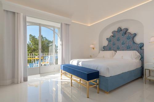 a bedroom with a blue and white bed and a balcony at La Sirenetta Luxury Suite Positano in Positano