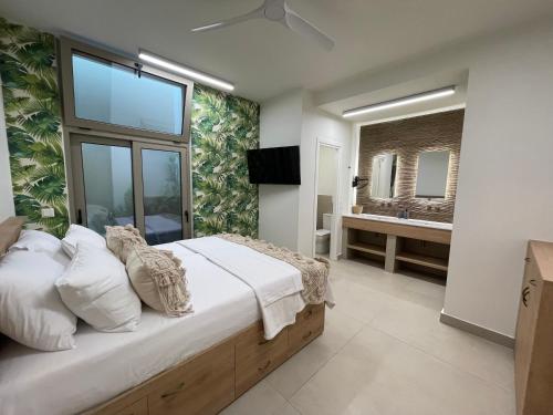 a bedroom with a large bed and a bathroom at C'est La Vie Beach Villa in Amoopi