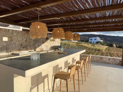 a kitchen with a bar with chairs and a view at C'est La Vie Beach Villa in Amoopi