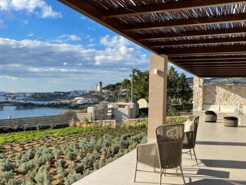 a patio with two chairs and a view of the water at C'est La Vie Beach Villa in Amoopi