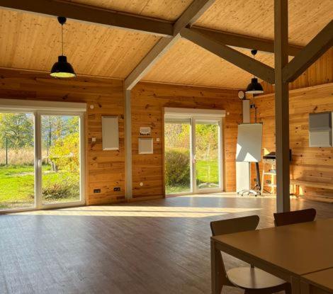 Cette grande chambre est dotée de murs en bois, d'une table et de chaises. dans l'établissement Camping Osenbach, à Osenbach