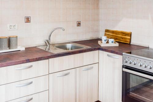 a white kitchen with a sink and a stove at Apartma Brešan in Kobarid