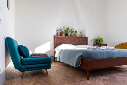a bedroom with a bed and a blue chair at Agriturismo Morani in Santa Severa