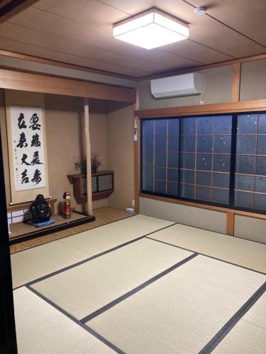 a room with a large window and a room with a rug at 自然体験と石窯のある古民家民泊アジールAsyl in Hirosaki