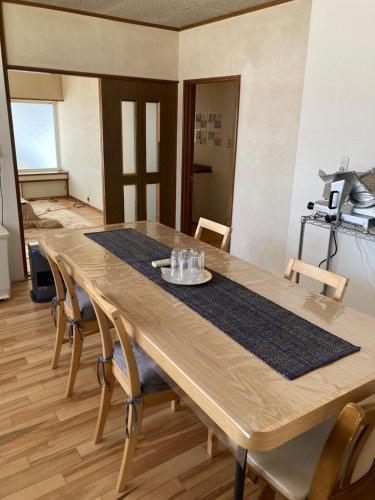 a wooden table in a room with chairs around it at 自然体験と石窯のある古民家民泊アジールAsyl in Hirosaki