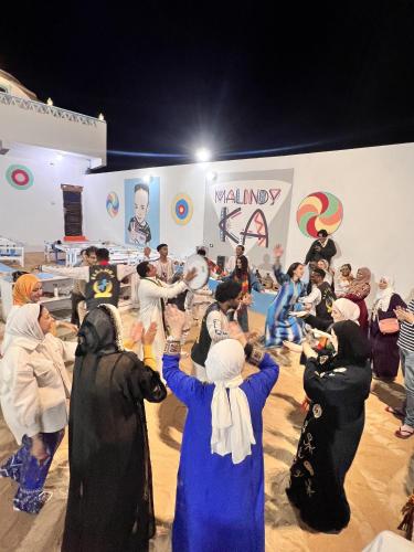 a group of people dressed in costumes dancing in a room at malindy KA ماليندى كا in Aswan