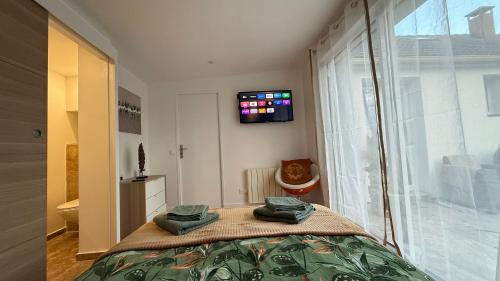 Μια τηλεόραση ή/και κέντρο ψυχαγωγίας στο Chambres d'Hôtes en pleine nature à 7mn du Parc Disney