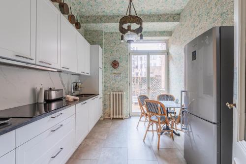 une cuisine avec des armoires blanches et une table avec des chaises dans l'établissement Maison Koch · Maison bourgeoise - 240 m2, à Strasbourg