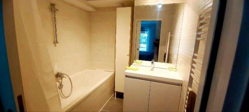 une salle de bain blanche avec une baignoire et un lavabo dans l'établissement Bel Appartement climatisé à 500m des plages de sable et des commerces, à Cavalaire-sur-Mer
