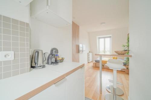 a kitchen with white counters and a white counter top at Charming studio near Paris in Saint-Ouen
