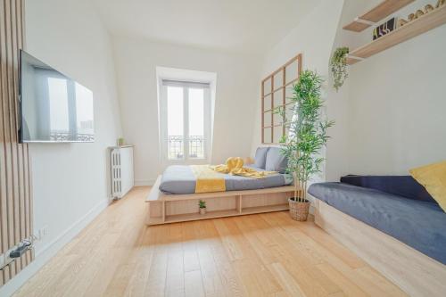 une chambre avec un lit et un canapé bleu dans l'établissement Charming studio near Paris, à Saint-Ouen