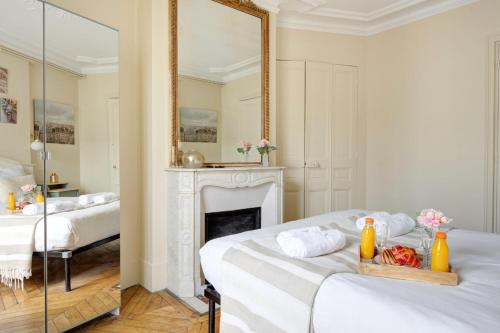 une chambre avec deux lits et un miroir dans l'établissement La Plume Suite A Haven of Peace in Montorgueil, à Paris