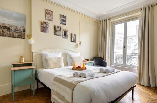 une chambre avec un grand lit avec des serviettes dessus dans l'établissement La Plume Suite A Haven of Peace in Montorgueil, à Paris
