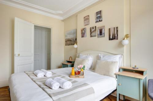 - une chambre avec un lit blanc et un plateau de serviettes dans l'établissement La Plume Suite A Haven of Peace in Montorgueil, à Paris