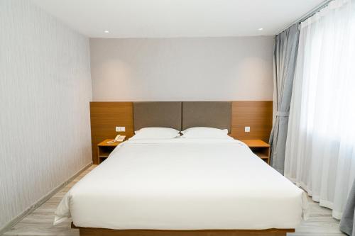 a bedroom with a large white bed and a window at Aurea Delight Hotel in Phnom Penh