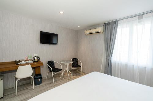 a hotel room with a bed and a table and chairs at Aurea Delight Hotel in Phnom Penh