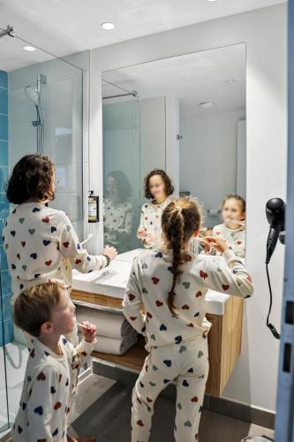 a group of children in pajamas standing in front of a mirror at Akena Nantes Rezé Aéroport in Rezé
