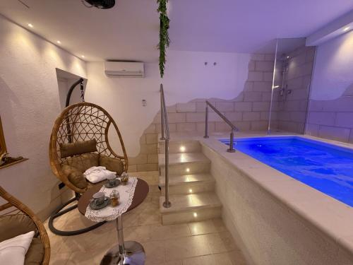 a room with a swimming pool and a chair next to a tub at Dimora Palermo with private pool in Palermo