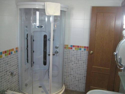 um chuveiro com uma porta de vidro na casa de banho em Hotel Verona em Puertollano
