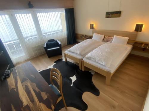 a room with a bed and a chair in it at Bärnsicht Panorama Hotel in Wasen