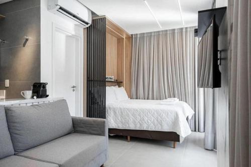 a hotel room with a bed and a couch at ZEE Studios by Viva - Studios a 200m da beira-mar norte in Florianópolis