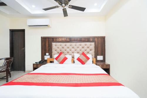 a bedroom with a large bed with red pillows at Hotel Atlantis Continental in New Delhi