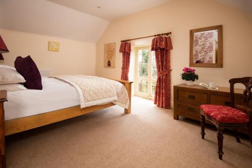 ein Schlafzimmer mit einem Bett, einer Kommode und einem Fenster in der Unterkunft Dairy Cottage in Knapton